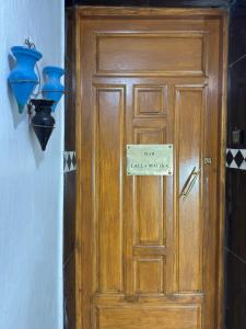 a wooden door with a sign on it at Dar lalla Malika in Rabat