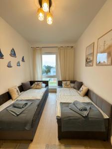 a living room with two beds and a couch at Let's Sea Positive Vibe apartment in Gąski +27 photos