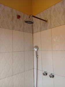 a shower with a shower head in a bathroom at Kilimanjaro Budget in Moshi +17 photos