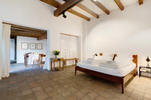 a bedroom with a large bed and a table at Loft Im Künstlerhaus in Riegel am Kaiserstuhl