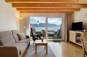 a living room with a couch and a view of the ocean at Merk Ferienwohnungen Gbr in Bodman-Ludwigshafen