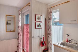a small kitchen with a sink and a window at Möve Aba Bungalow 67 in Rerik +24 photos