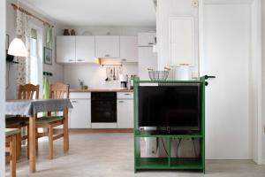 a living room with a tv on a stand in a kitchen at Möve Aba Bungalow 64 in Rerik