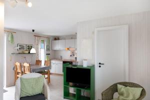 a kitchen and living room with a tv and chairs at Möve Aba Bungalow 64 in Rerik