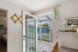 a door leading into a room with a balcony at Möve Aba Bungalow 64 in Rerik