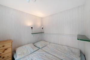 a small bedroom with a bed and two lights on the wall at Möve Aba Bungalow 64 in Rerik
