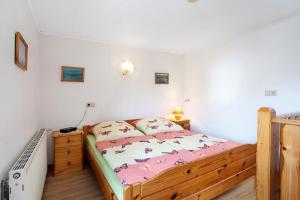 a bedroom with a wooden bed with pink sheets at Ferienhaus Pahnke in Bergen auf Rügen +18 photos