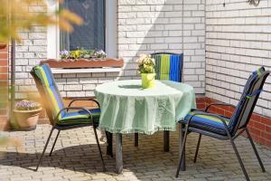 a table with three chairs and a vase with flowers on it at Ferienhaus Pahnke in Bergen auf Rügen