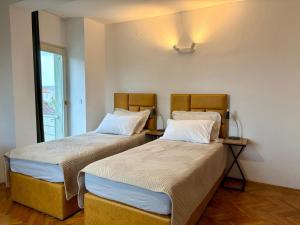 two beds sitting next to each other in a room at Old Town Heritage by Mrav in Sukošan