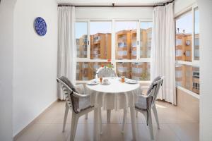 ein weißer Tisch und Stühle in einem Zimmer mit Fenster in der Unterkunft Bloque 78 in Torrox
