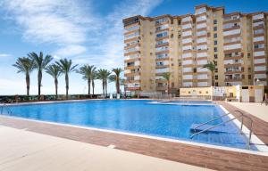 ein großer Swimmingpool mit Palmen vor einem Gebäude in der Unterkunft Bloque 78 in Torrox