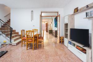 a dining room with a table and chairs and a television at La Matea in Llaurí
