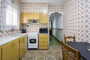 a kitchen with yellow cabinets and a white stove top oven at La Matea in Llaurí