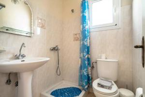 a bathroom with a sink and a toilet and a window at Anemona studio A in Kefallonia +12 photos