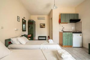 a bedroom with two beds and a small kitchen at Anemona studio A in Kefallonia