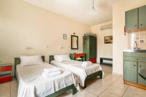 a room with two beds and a kitchen with a sink at Anemona studio A in Kefallonia