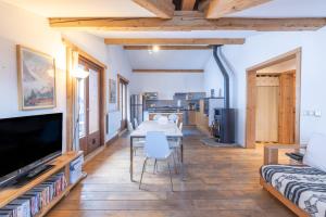 a living room with a table and a tv at Appartement style loft Chamonix in Les Houches