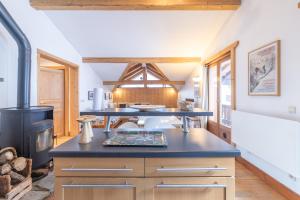 a large kitchen with a stove in a room at Appartement style loft Chamonix in Les Houches +13 photos