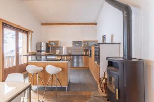 a kitchen with a stove and some stools at Appartement style loft Chamonix in Les Houches