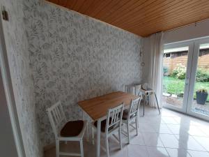 a dining room with a wooden table and chairs at Ferienhaus Dorfidylle in Oberzent