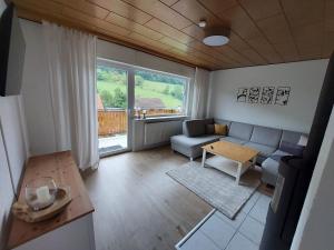 a living room with a couch and a table at Ferienhaus Dorfidylle in Oberzent