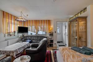 a living room with a leather couch and a table at Ferienwohnung Behrens-Reinke in Albstadt