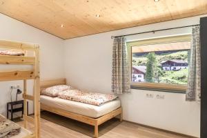 a bedroom with a bunk bed and a window at Kwelle zur Natur Gamsberg in Obernberg am Brenner