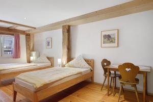 ein Schlafzimmer mit zwei Betten, einem Tisch und Stühlen in der Unterkunft Müllerjörgenhof in Gutach