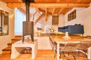 a living room with a wood stove and a table at L'atelier M in Quaix