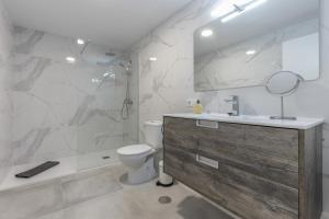 a bathroom with a sink and a toilet and a mirror at Edificio El Baifo Loco - Constantin in Gran Tarajal +17 photos