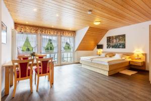 a bedroom with a bed and a table and chairs at Glöcklehof in Todtnau