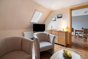 a living room with two chairs and a television at Ferienwohnung Horstmann in Meldorf