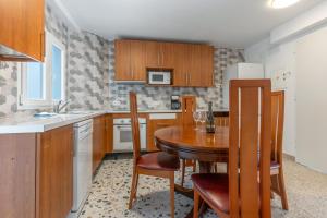 a kitchen with a wooden table with chairs and a sink at Edificio El Baifo Loco - Constantin in Gran Tarajal