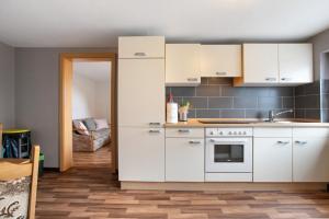 a kitchen with white cabinets and a stove at Ferienwohnung Horstmann in Meldorf