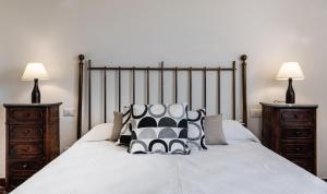a bedroom with a large bed with two night stands at Villa Aquila Giardino in Is Molas  +27 photos