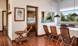 a kitchen with a table and chairs in a room at Villa Aquila Giardino in Is Molas 