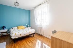 a bedroom with a bed and a blue wall at Maison Ker Morin La Gacilly in La Gacilly