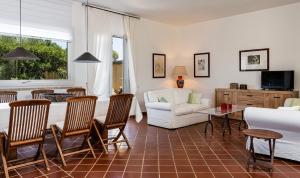a living room with a bed and a couch and a table at Villa Aquila Giardino in Is Molas 