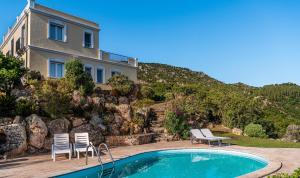a house with a swimming pool in front of a house at Villa Aquila Giardino in Is Molas 