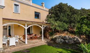 an external view of a house with a garden at Villa Aquila Giardino in Is Molas 