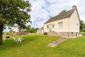 a cottage with a table and chairs in the yard at Maison Ker Morin La Gacilly in La Gacilly