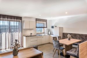 a kitchen and living room with a table and chairs at Aster Moments Apt Marie in San Genesio Atesino
