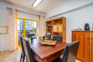 a dining room with a wooden table and chairs at Sweet home rp – t1 em portimão in Portimão