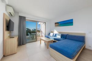 a hotel room with a blue bed and a balcony at Apartamento Aquamarina 7 in Cala Ferrera