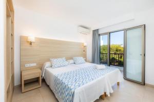 a bedroom with a large bed and a balcony at Apartamento Aquamarina 7 in Cala Ferrera +16 photos