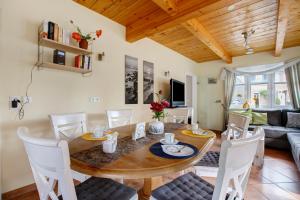 a dining room and living room with a wooden table and chairs at Ferienhaus Siegfried in Niebüll