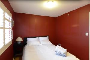 
a bedroom with a bed, a lamp, and a window at Marpole Guest House in Vancouver
