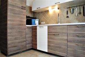 a kitchen with wooden cabinets and a white refrigerator at Villa Florida 2 with private pool in San Teodoro