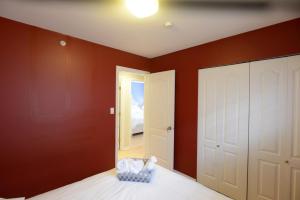 
a bedroom with a blue wall and a white bed at Marpole Guest House in Vancouver
