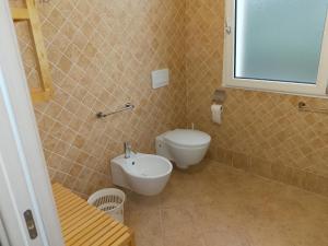 a bathroom with a toilet and a sink at Villa Florida 2 with private pool in San Teodoro +5 photos